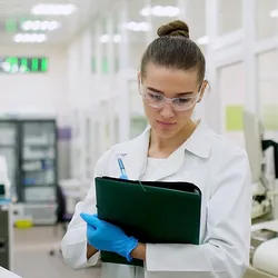 A lab quality manager checks off an item on a checklist while inspecting the lab