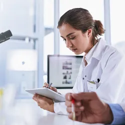 A young female scientist works on a tablet computer