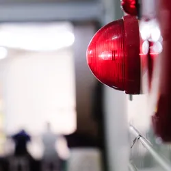 a red alarm bell mounted on a wall symboloc of scientists raising the alram for reaseach