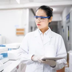 an Asian woman working in a laboratory illustrating the comcept of creating language inclusive research spaces