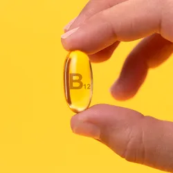 hand holding a clear B vitamin, B complex vitamins may play a role in dreaming and nightmares
