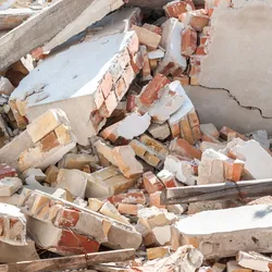 Collapsed concrete and brick rubble illustrating a disaster zone for soft robotics search and rescue.