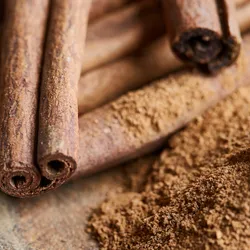 A photo of sticks of cinnamon and powdered cinnamon, which may affect drug metabolism in the body
