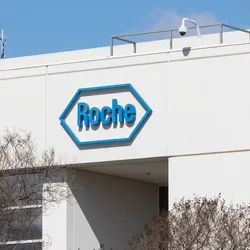 The exterior of a modern Roche facility, with the company’s blue logo prominently displayed on the building. The image represents Roche’s $50 billion US investment as part of a broader pharmaceutical tariff response strategy.