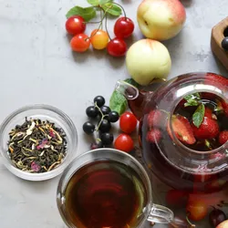 A colorful display of black tea, strawberries, cherries, apples, and other flavonoid-rich foods on a table.