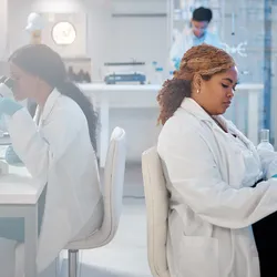 Scientists in a modern laboratory conducting research and data analysis, representing scaling lab operations.