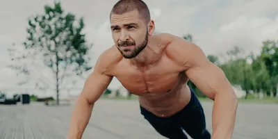 Man without shirt doing push-ups, exhibiting healthy levels of testosterone for men.