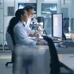 Two scientists communicating in the lab.
