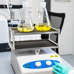 Gloved scientist operating a lab shaker.