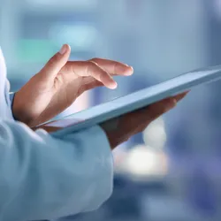Scientist holding a tablet, symbolic of a paperless lab.