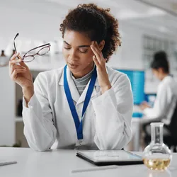 Scientist in the lab looking stressed from burnout.