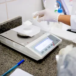 Scientist using a properly maintained analytical balance.