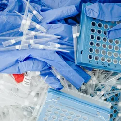 Discarded lab gloves, pipette tips, and trays highlight the need for sustainable lab packaging