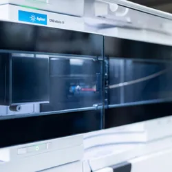 Close-up of the Agilent 1290 Infinity III liquid chromatography system, showing the front panel and internal tubing, highlighting its sleek, modern design in a laboratory setting.