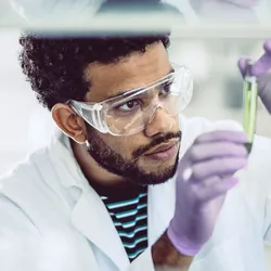 Scientist examining chemical sample in lab under TSCA compliance protocols.
