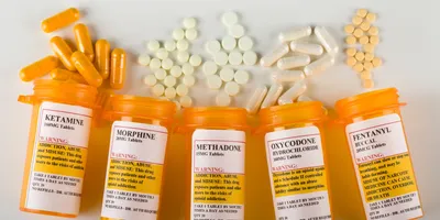 various bottles of drugs spilled on the counter including ketamine suggesting if ketamine is an opioid