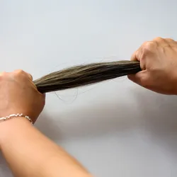 Human hands pulling a bunch of hair.