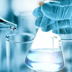 Gloved hand holding a flask of purified water beside a pipette in a laboratory setting