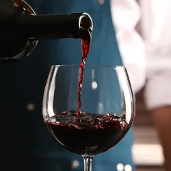 Man pouring wine into a glass following titration.