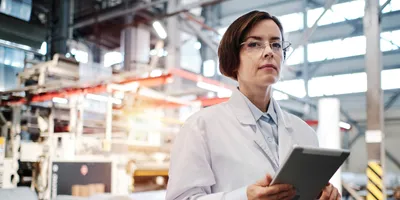 Female in a lab coat with a clipboard, symbolic of supplier qualifications.