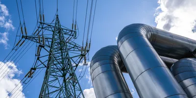 Electrical pylon next to gas pipes, symbolic of converting captured carbon to electricity.