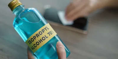 Person holding a bottle of isopropyl alcohol.