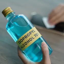 Person holding a bottle of isopropyl alcohol.