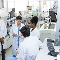 Diverse medical researchers in lab coats having a collaborative discussion to prevent groupthink.