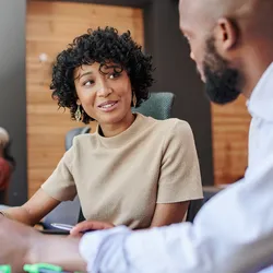 A manager and an employee discuss documents in a meeting