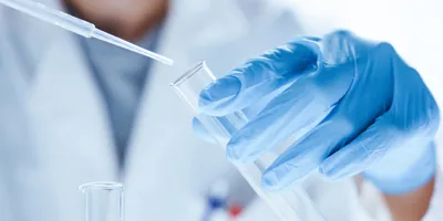 Scientist with a test tube and micropipette