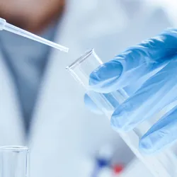 Scientist with a test tube and micropipette