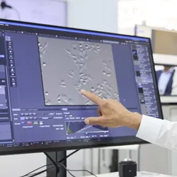 Person at an analytica trade fair pointing at scientific equipment