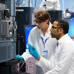 Lab technicians reviewing data on lab equipment, illustrating teamwork and improving accountability in labs through collaboration and shared responsibility