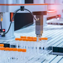 Robotic arm handling test tubes with orange caps in an automated pharmaceutical laboratory, showcasing advanced lab automation technology for drug discovery and analysis.