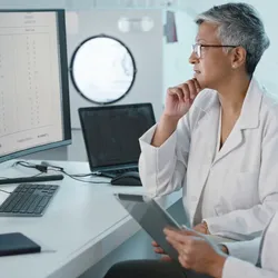 A lab manager and a scientist look at data on a computer. Standardized data is vital to scaling your lab's informatics capabilities.