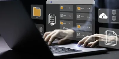 Person typing on a laptop with digital file and folder icons projected above the keyboard, representing data management and digital workflows in a laboratory information management system (LIMS).