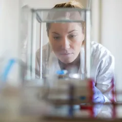 Scientist inspecting an analytical balance in a laboratory, emphasizing the role of leveling in accurate weight calibration and ISO 17025 compliance.