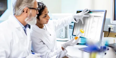 Scientists looking a computer with a LIMS