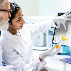 Scientists looking a computer with a LIMS