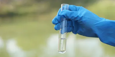 Test tube held by a gloved hand for PFAS analysis