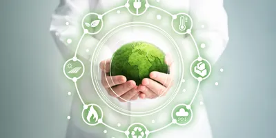Hands holding a green globe symbolizing sustainability in lab operations