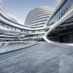 Modern futuristic office complex with curved, glass-covered architecture and tiered walkways, depicting a high-tech or corporate innovation campus.
