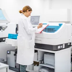 Three scientists working in a modern lab, one viewing a clipboard, representing integrating new equipment into the lab