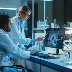 Female Research Scientist with Bioengineer Working on a Personal Computer with Screen Showing Virus Analysis Software User Interface. Scientists Developing Vaccine, Drugs and Antibiotics in Laboratory