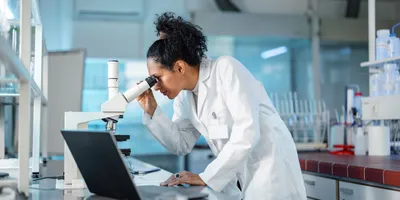 Laboratory researcher examining cells through a microscope