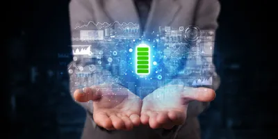 Hands holding a digital battery icon and data graphs, representing next-generation battery technologies.