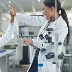 Female scientists high-fiving as a form of encouragement in labs