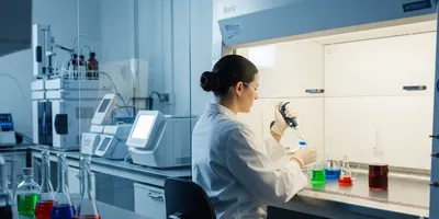 Laboratory technician analyzing food additives with a pipette.
