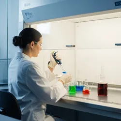 Laboratory technician analyzing food additives with a pipette.