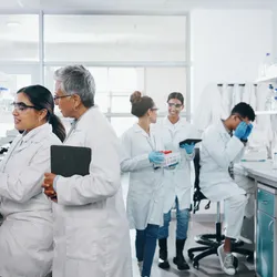 Laboratory setting with multiple researchers emphasizing the importance of acoustic control.